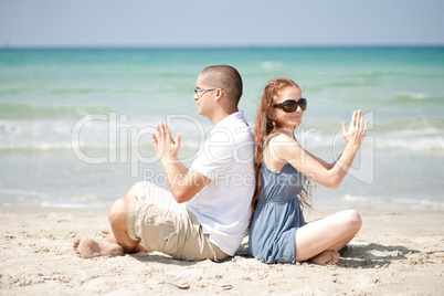 Couple doing exercises on the beach sand