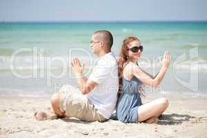 Couple doing exercises on the beach sand