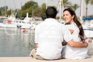 Rear view of young couple sitting at the harbour