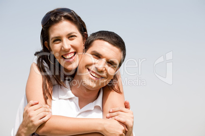 Happy young guy piggybacking his girlfriend