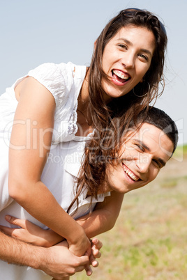 Smiling young couple piggybacking