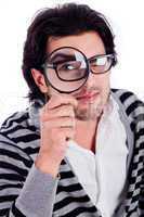 young man looking stright with a magnifying glass