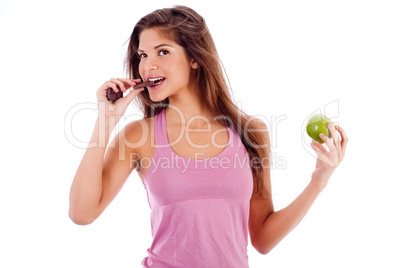 sexy girl biting a chocklate and keep the apple in other hand