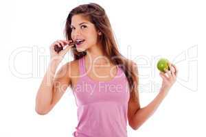 sexy girl biting a chocklate and keep the apple in other hand