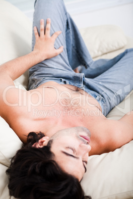 young man sleping deeeply by laying on the sofa