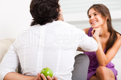 man hiding fruit from his girlfriend