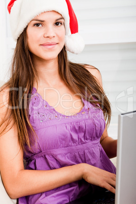 beautiful young women wearing santa's hat using laptop