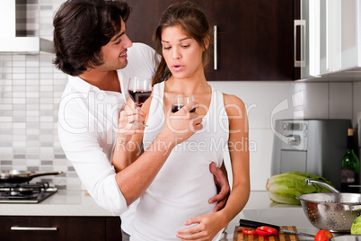 young couple enjoying their wine  in kitchen