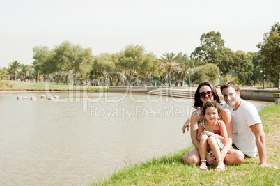 Family sitting near the lake