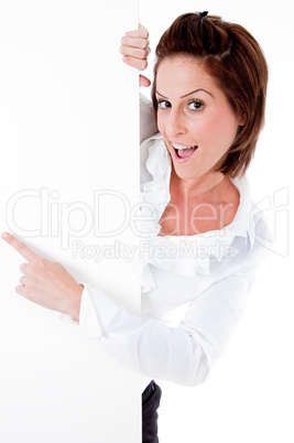 Happy young female holding a blank billboard, pointing at it
