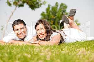 beautiful young Couple lie down on grass