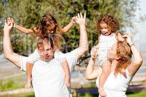 Daughters enjoying their ride on parents shoulders