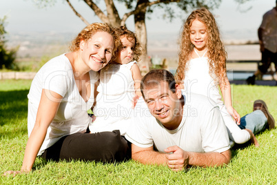 Family of four lying in grass