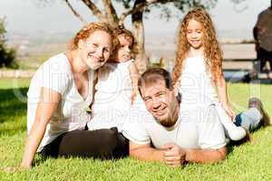 Family of four lying in grass