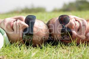 Happy young couple smiling on a lawn