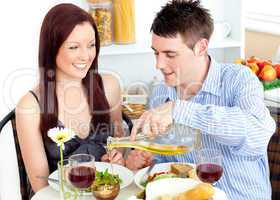 Radiant couple having dinner together in the kitchen