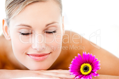 Close-up of a bright woman lying on a massage table with a flowe