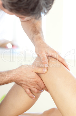 Close-up of a young physical therapist giving a leg massage