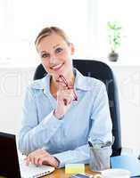 Confident businesswoman holding her glasses in her office