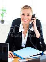 Radiant businesswoman talking on phone in her office
