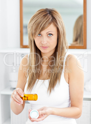 Diseased caucasian woman taking pills looking at the camera in t