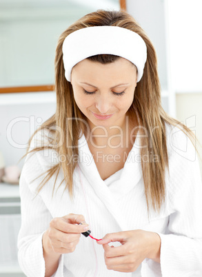 Sophisticated caucasian woman varnishing her fingernails in the