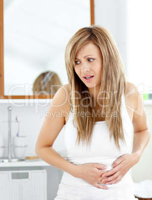 Attractive woman having a stomachache in the bathroom