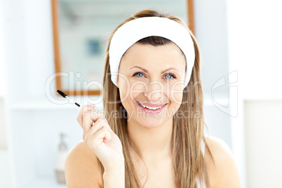 Radiant young woman using mascara in the bathroom