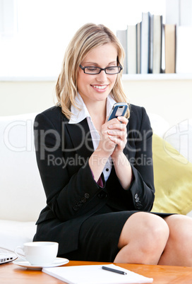 Pretty businesswoman sending a text message with her cellphone s