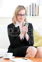 Pretty businesswoman sending a text message with her cellphone s