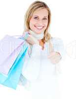 Delighted woman with thumb up holding shopping bags