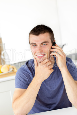 Handsome young man talkng on phone and smiling at the camera