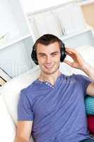 Relaxed young man listening to music with headphones looking at