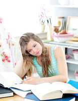 Bored caucasian student doing homework sitting in the kitchen