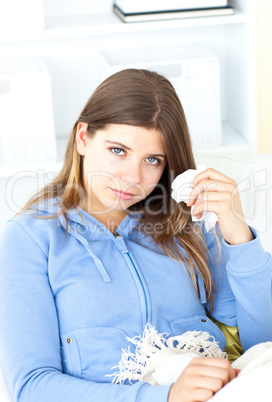 Sick young woman holding a tissue
