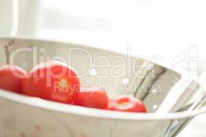 Fresh, Vibrant Roma Tomatoes in Colander with Water Drops
