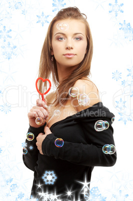lovely girl with heart-shaped blower and snowflakes