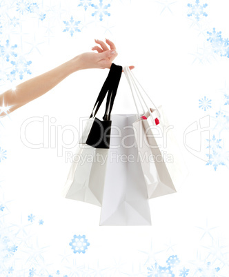 hand with shopping bags and snowflakes