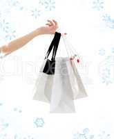 hand with shopping bags and snowflakes