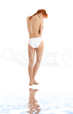 healthy redhead in white bikini panties on white sand