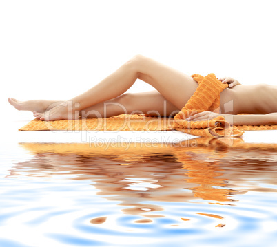 long legs of relaxed lady with orange towel on white sand #4