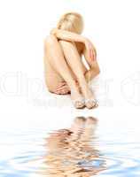 blonde in shoes sitting on white sand