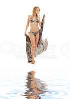 walking bikini girl with sarong  on white sand