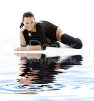 sporty girl in black leotard on white sand