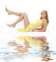 laying girl in yellow dress on white sand