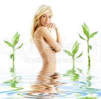 tanned blonde in water with green plants