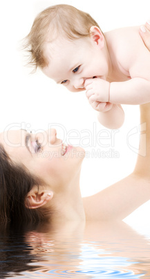 laughing blue-eyed baby playing with mom