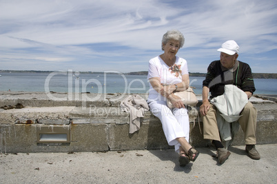 Senior couple sitting on wall