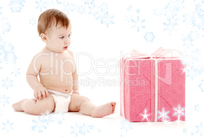 baby boy in diaper with big gift box and snowflakes