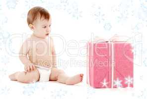 baby boy in diaper with big gift box and snowflakes